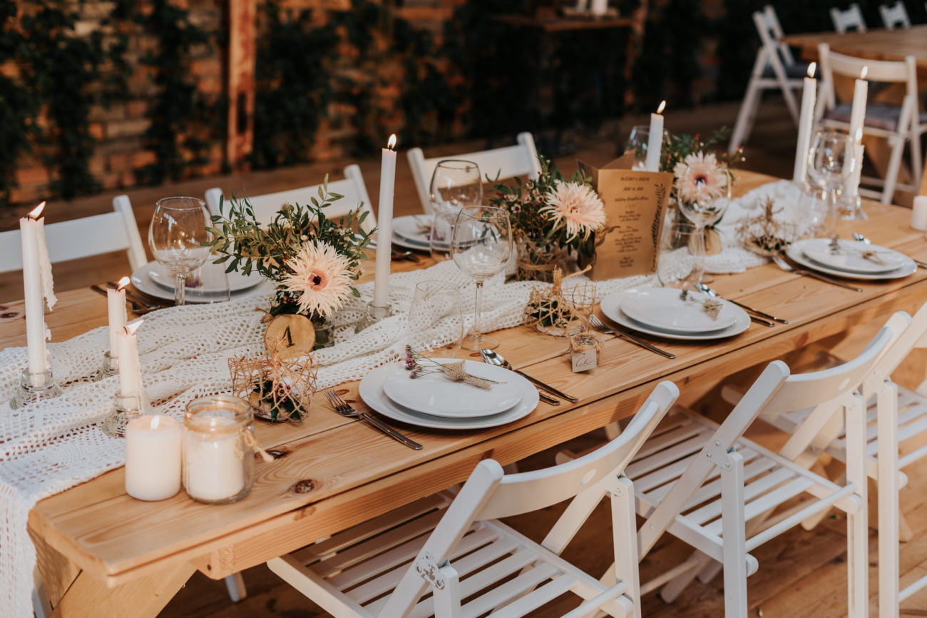 Dodatki i akcesoria na stół weselny, w tym eleganckie sztućce i obrusy.